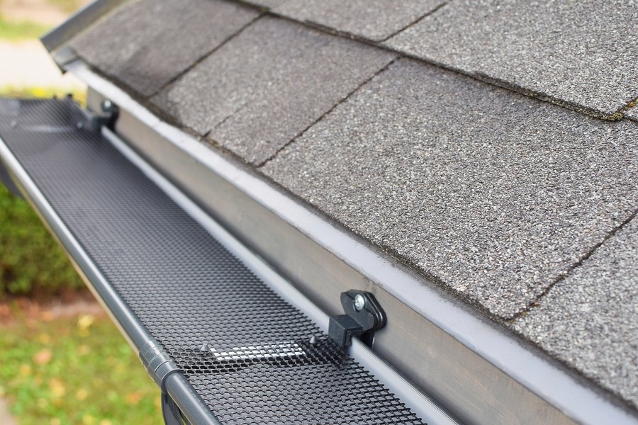 Plastic Guard Over New Dark Grey Plastic Rain Gutter On Asphalt