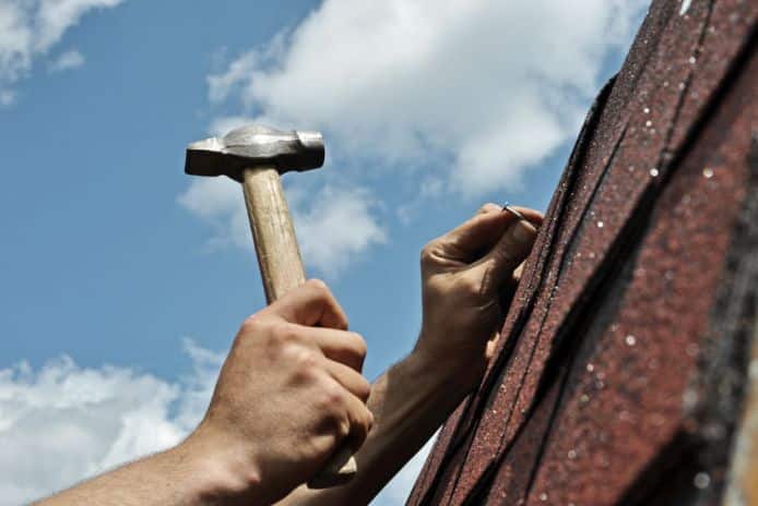 Picture of roofer fixing roof damage.